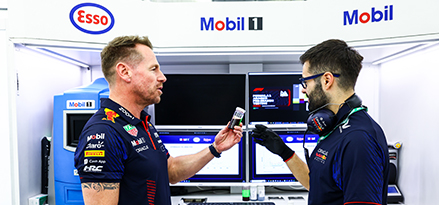 Red Bull mühendisi RB garajında konuşuyor ve arkasında Mobil 1 logosu var